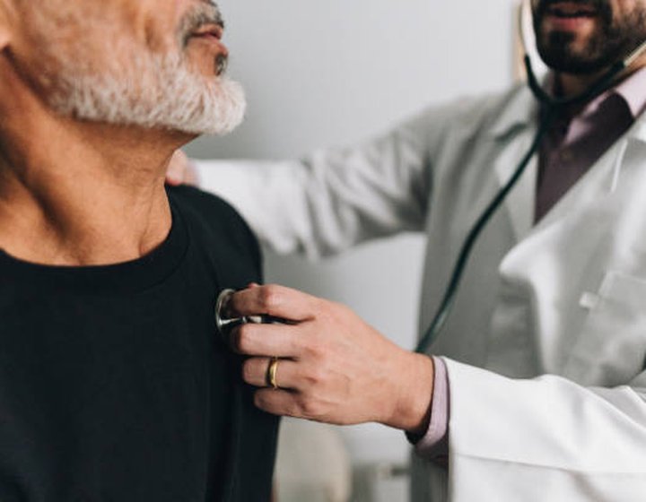 A clinician listening carefully while examining a patient